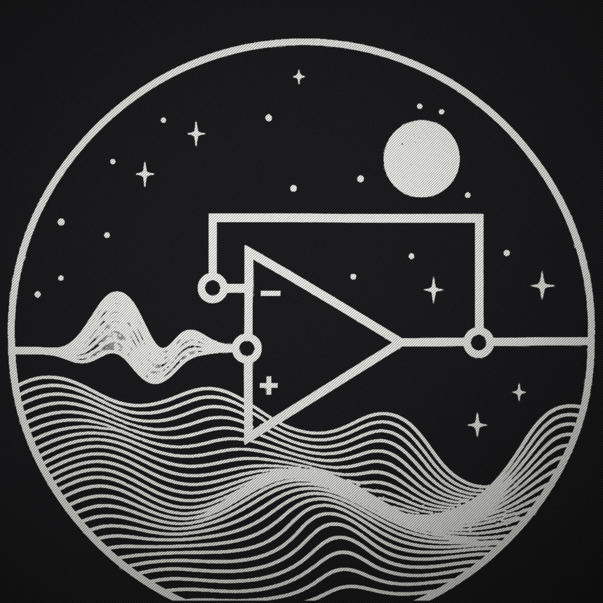 Close-up of the cream circular line art on black fabric: op-amp triangle, stars, moon and flowing wave lines.